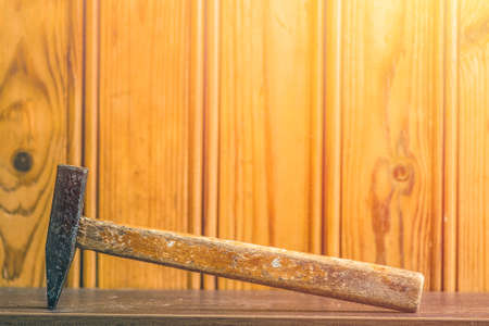 A hammer with a wooden handle on the background of boards. Work tool