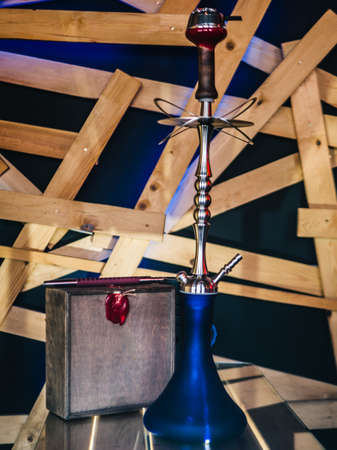 Beautiful glass hookah on a wooden table in a hookah barの写真素材
