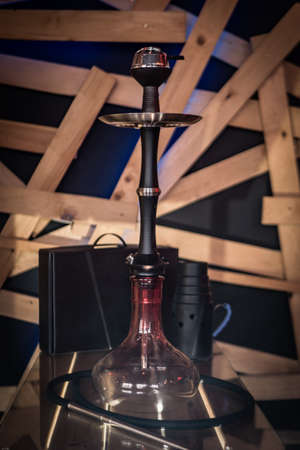 Beautiful glass hookah on a wooden table in a hookah bar