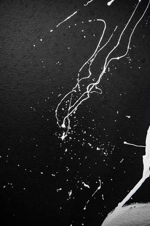 Texture of white paint on a black wall, graffiti, street art. Traces of paintbrush and brushの写真素材