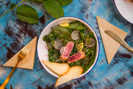 A delicious salad with greens on the table in the cafe. Salad on a white plateの写真素材