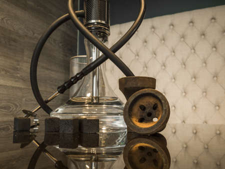 Beautiful glass hookah on a wooden table in a hookah barの写真素材