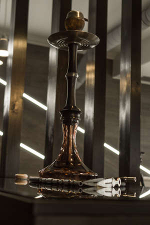 Beautiful glass hookah on a wooden table in a hookah bar