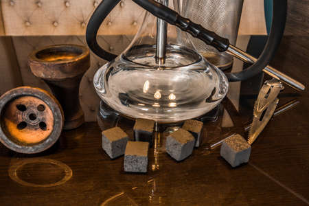 Beautiful glass hookah on a wooden table in a hookah bar