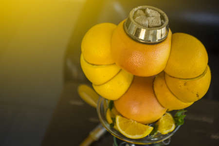 Beautiful glass hookah, with a fruit bowl, consisting of oranges and grapefruit. Handmade in a flask green syrup and lemonsの写真素材