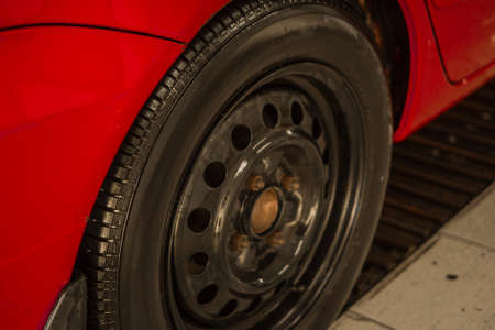 Red passenger car in the box at the car wash. Integrated washing under the pressure of water. Summer dayの写真素材