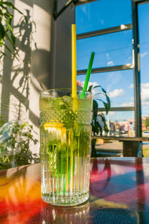 A glass of refreshing cocktail with ice. Mojito with mint, lime and lemon. Cafeの写真素材