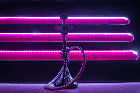 Beautiful glass hookah on the table in the bar. Bright lights