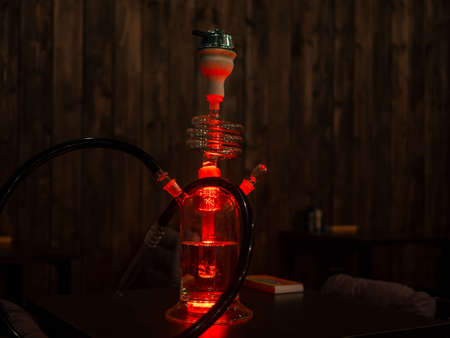 Beautiful glass hookah on the table in the bar. Bright lights