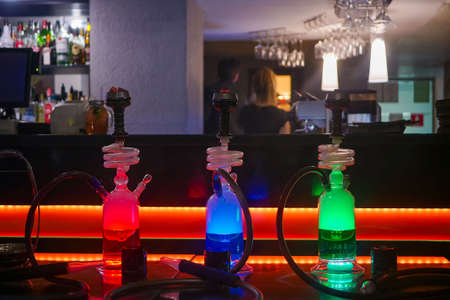 Beautiful glass hookah on the table in the bar. Bright lights