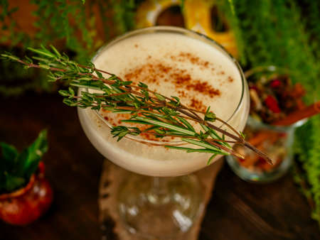 Brown cocktail in a glass goblet on a long leg. In the tropical garden. On a flat stone. Daylightの写真素材