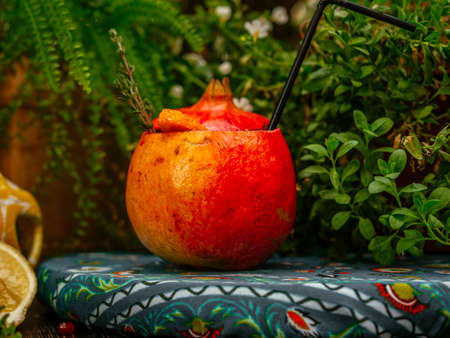 Alcoholic cocktail poured inside pomegranate. Pomegranate is used as a glass. Tropical flavorの写真素材