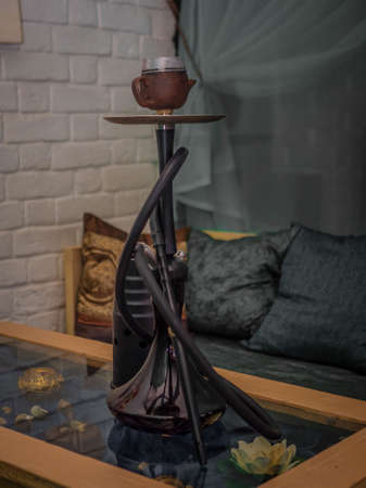 New hookah on a table in an oriental cafe. A variety of flavors of tobacco.