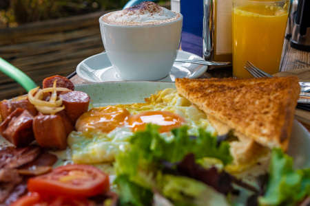Tasty breakfast in the early morning in a summer cafe. Sunny bright light. June