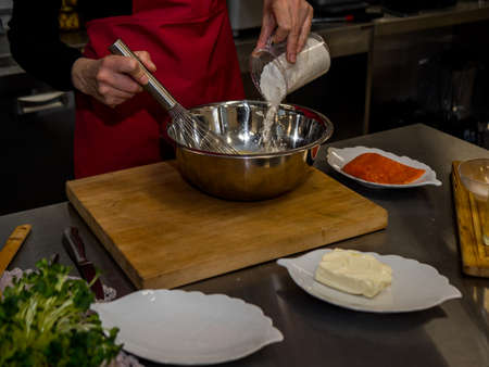 The process of making pancakes. Cook in the kitchen makes the dough.の写真素材