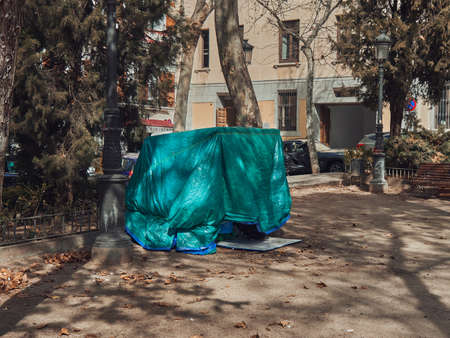 Polyethylene shelter for the homeless in a city park, a man hid in a hut. Dayの写真素材