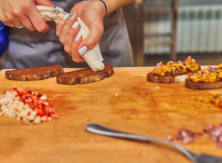 The process of making delicious bruschetta on crispy toasted bread. Femaleの写真素材