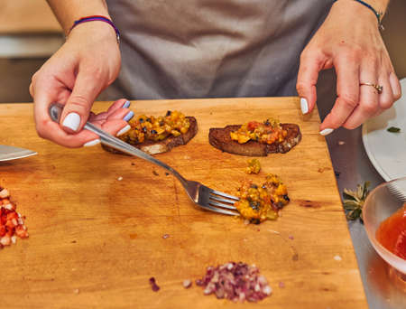 The process of making delicious bruschetta on crispy toasted bread. Femaleの写真素材