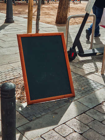 Chalk board with a wooden frame on the street near a small cafe. Summerの写真素材