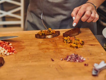 The process of making delicious bruschetta on crispy toasted bread. Femaleの写真素材