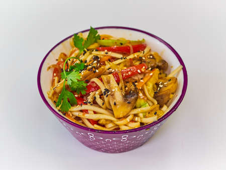 Udon noodles with meat in a plate on a white surface.の写真素材