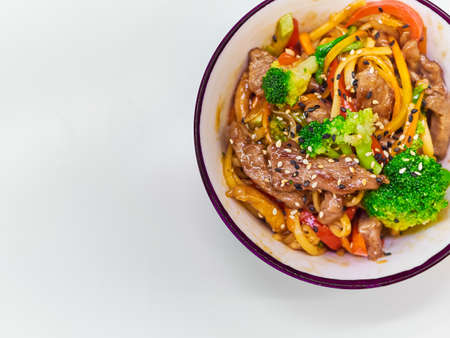 Udon noodles with meat in a plate on a white surface.の写真素材