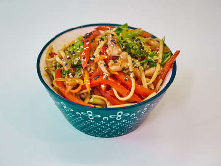 Udon noodles with meat in a plate on a white surface.の写真素材