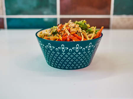 Udon noodles with meat in a plate on a white surface.の写真素材