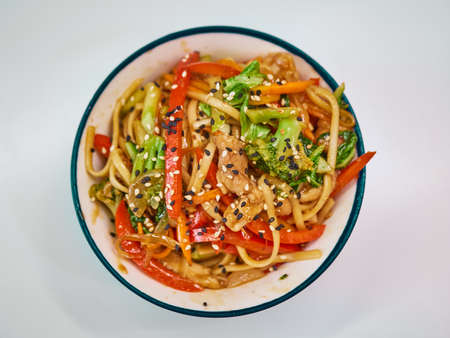 Udon noodles with meat in a plate on a white surface.の写真素材