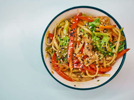 Udon noodles with meat in a plate on a white surface.の写真素材