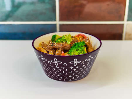 Udon noodles with meat in a plate on a white surface.の写真素材