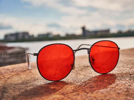 Old red sunglasses on a concrete surface. Scratched glass. Dayの写真素材