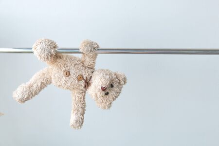 little teddy bear hang the bar by his hand to exercise at out door playgroundの写真素材