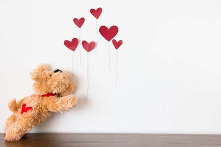 Cute puppy  with red heart balloonの写真素材