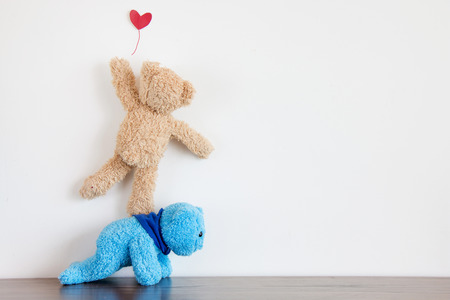 Two teddy bear are love,Teddy bear trying catch red heart balloonの写真素材