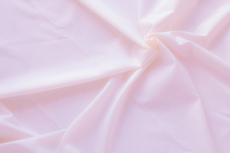 Creased pink cloth material fragment as a backgroundの写真素材