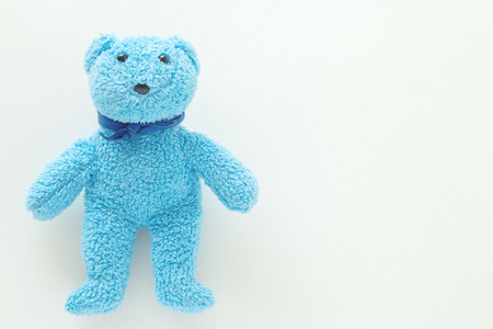 Cute blue teddy bear on white fabric backgroundの写真素材