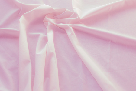 Creased pink cloth material fragment as a backgroundの写真素材