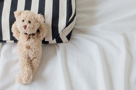 top view of teddy bear is relaxing on black&white fabric a bed background , Relaxing conceptの写真素材