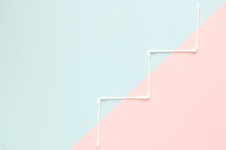 White cotton buds on two tone color pastel backgroundの写真素材