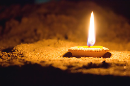 One light candle burning brightly on the floorの写真素材