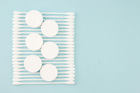 Facial mask sheets compressed type and White cotton buds  on blue backgroundの写真素材