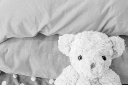 Lonely teddy bear is lay down on the bed,He lose power life,Black and white styleの写真素材