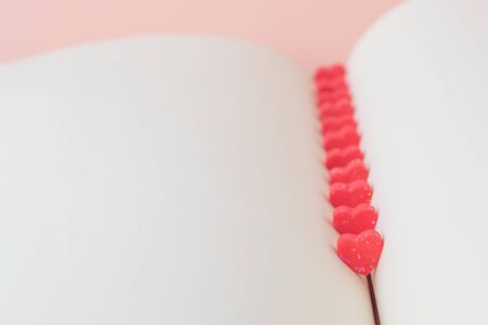 Sweet mini hearts in red on a bookの写真素材