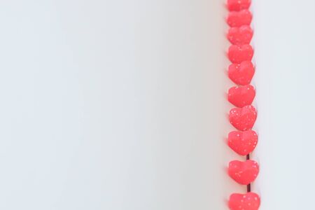 Sweet mini hearts in red on a book 	