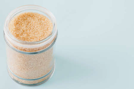 Sugar in a glass jar on blue backgroundの写真素材
