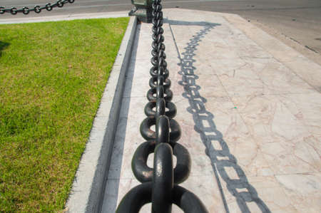 Chain on gray concrete floor and grass backgroundの写真素材