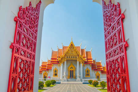 The Marble Temple, Wat Benchamabophit Dusitvanaram with red gate and blue sky background , Bangkok THAILANDのeditorial素材