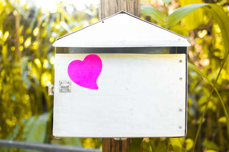 Blank note pad or sticky notes pink on post box with sunlight background,Happy valentine day.
