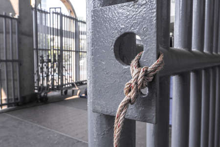 Ropes tied with grey  grille doorの写真素材